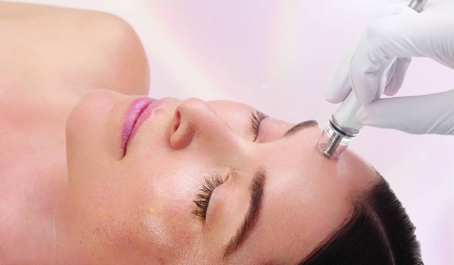 A woman receives a DiamondGlow facial treatment, experiencing a rejuvenating exfoliation and infusion process for radiant, glowing skin.