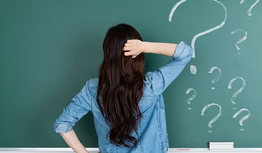 Confused girl in front of chalk board